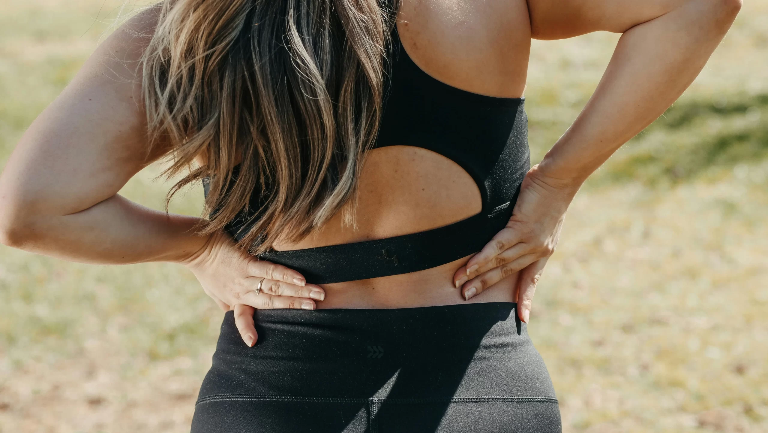 A woman holding her back in pain.